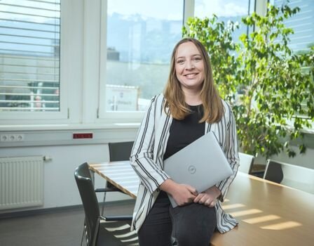 Person mit Laptop im modernen Büro Person mit Laptop im modernen Büro